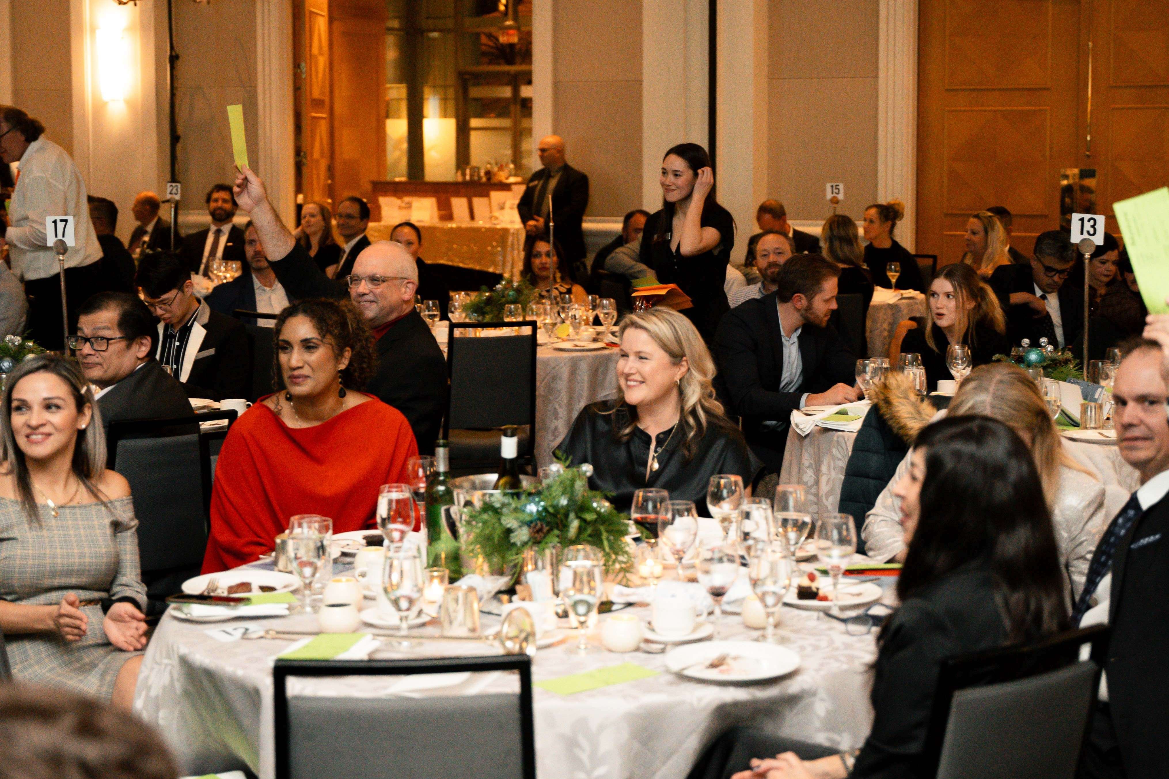 Community members seated around tables at a Mission Possible celebration or fundraising event