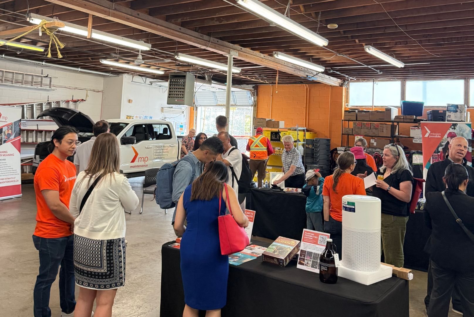 Guests at Mission Possible's Open House stand in the warehouse. They had a chance to celebrate, connect, and look ahead with the community that makes our work possible. 